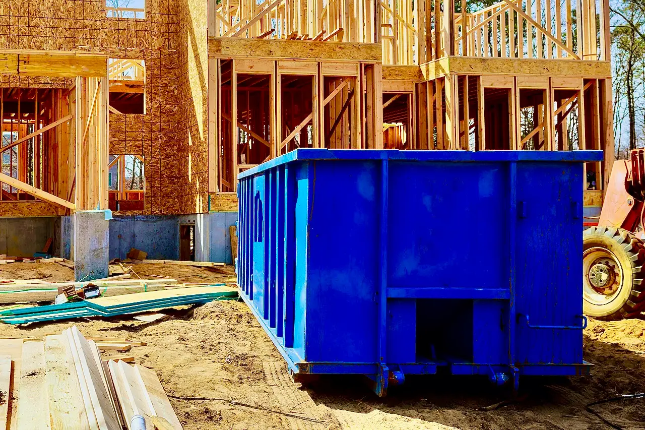 Large blue dumpster at a commercial construction project.